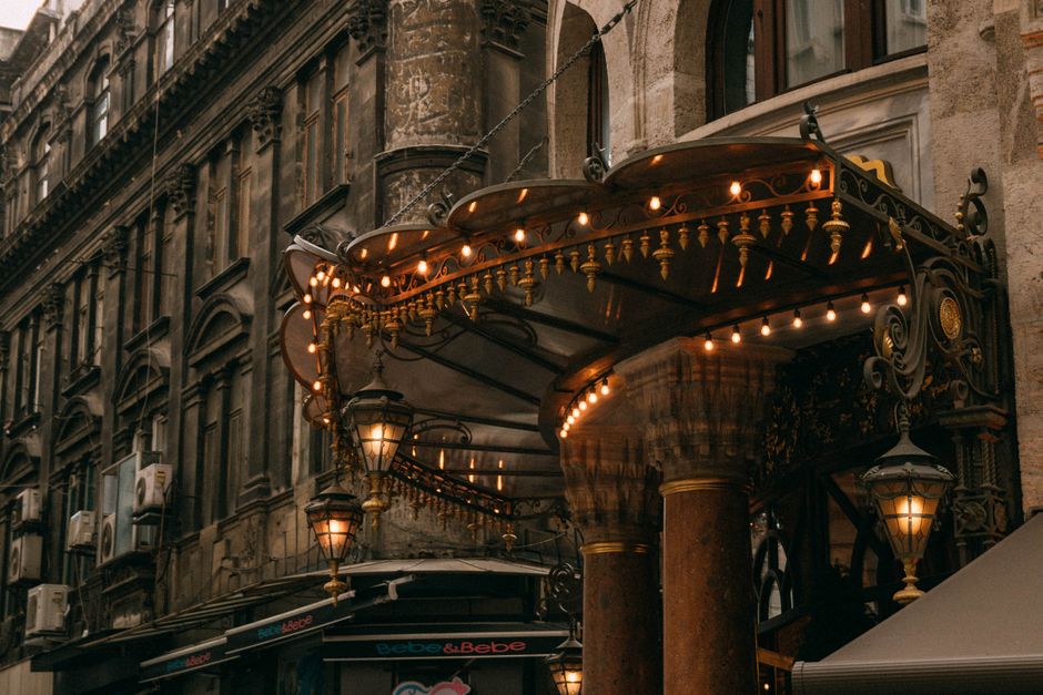 Vintage ornate canopy on a historic city building with warm lighting and architectural details.