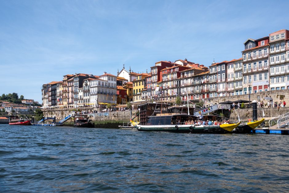 Scenic view of Porto's historic riverside with colorful buildings and traditional boats.
