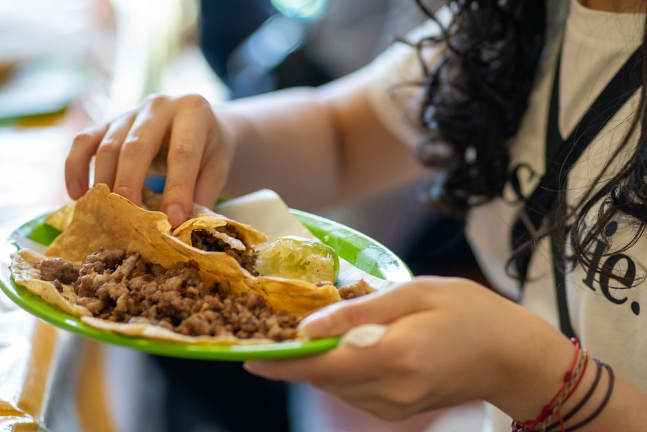 Close-up of a person enjoying traditional Mexican tacos in Mexico City. Perfect for food enthusiasts.