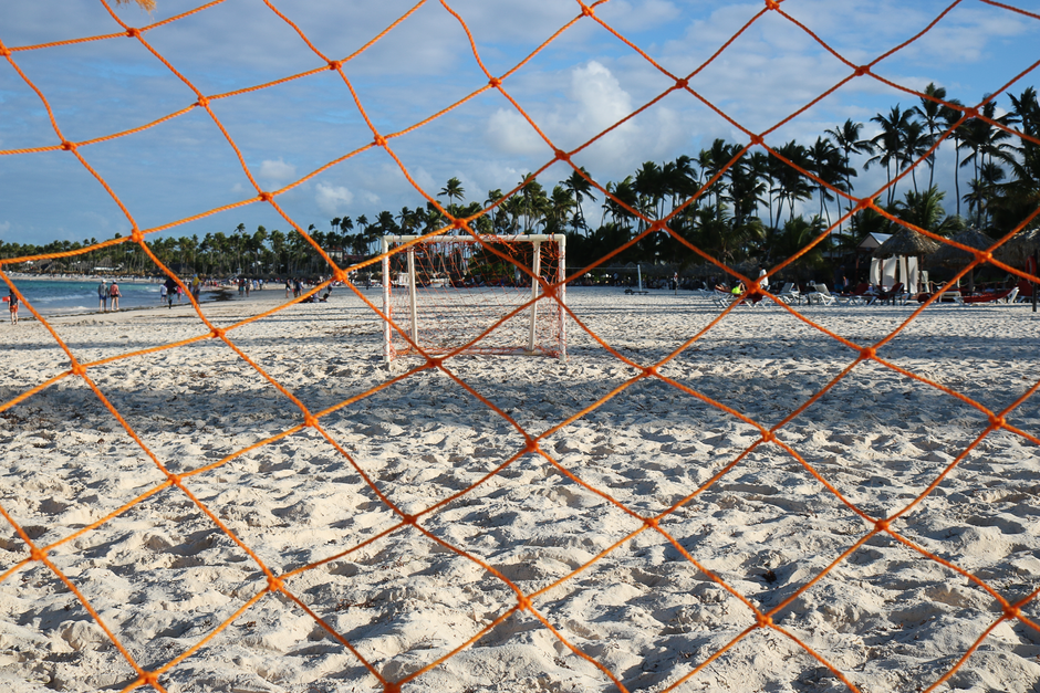Orange soccer net on a sandy beach in Punta Cana, Dominican Republic, perfect for a tropical sports setting.