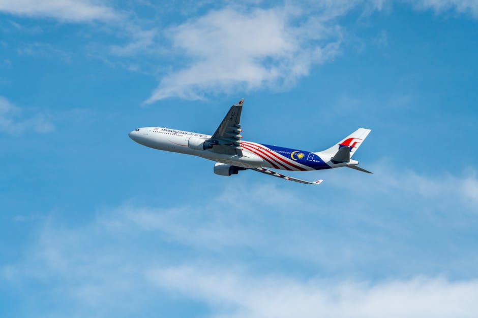 A Malaysia Airlines plane flying high with clear blue sky background. Stunning view of aviation in motion.