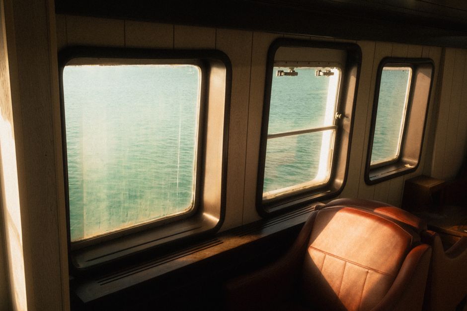 Tranquil view through ferry windows capturing İzmir's beautiful seaside.