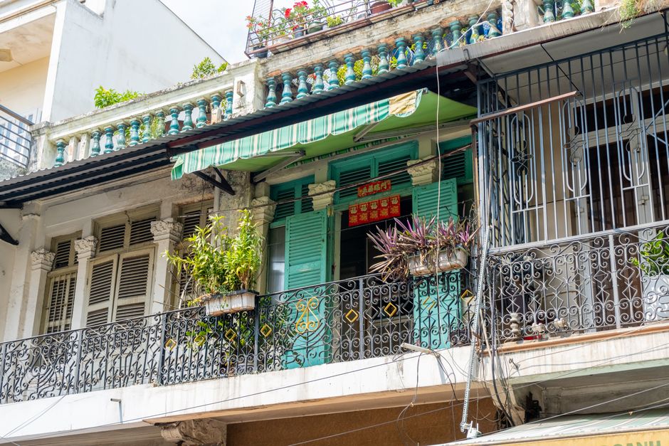A vibrant balcony with potted plants and ornamental railings in Ho Chi Minh City.