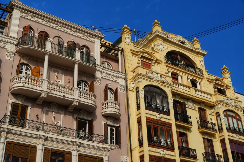 Detailed view of ornate European-style building facades with balconies under a clear blue sky.