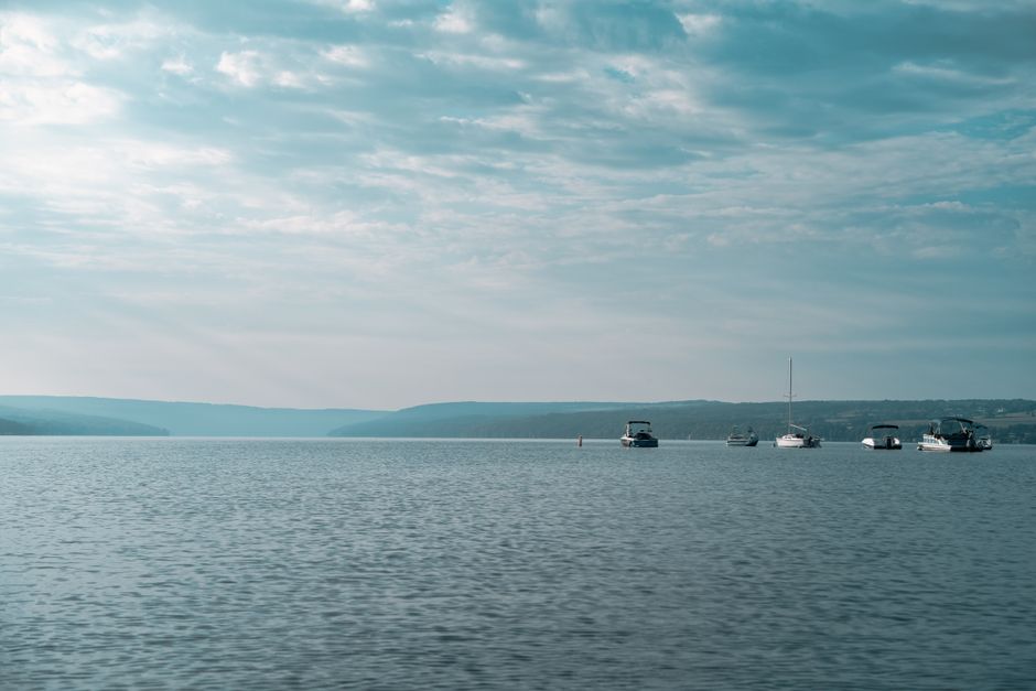 Peaceful view of boats on Skaneateles Lake under a cloudy sky in New York.