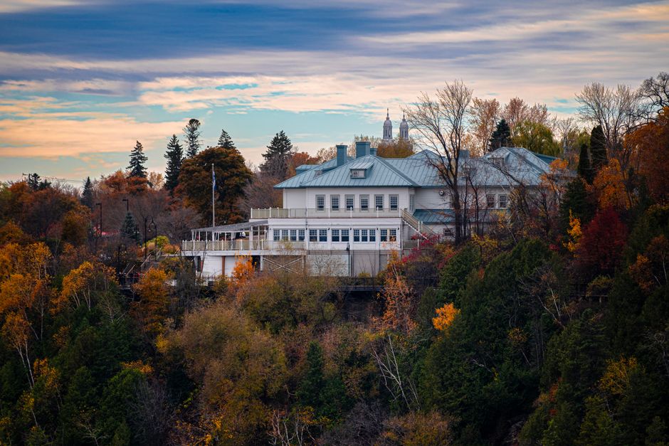 Picturesque autumn scene with a historic building amidst fall foliage in Québec City, Canada.