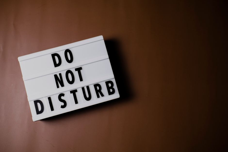 A 'Do Not Disturb' message board on a brown background for privacy and relaxation themes.