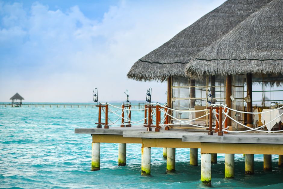 Scenic view of a tropical overwater bungalow on a crystal-clear sea, perfect for a luxurious vacation.