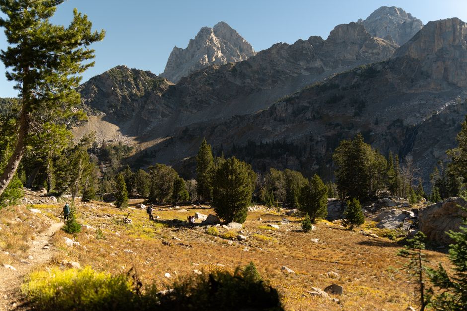 Hikers explore a beautiful trail in Grand Teton National Park during fall.