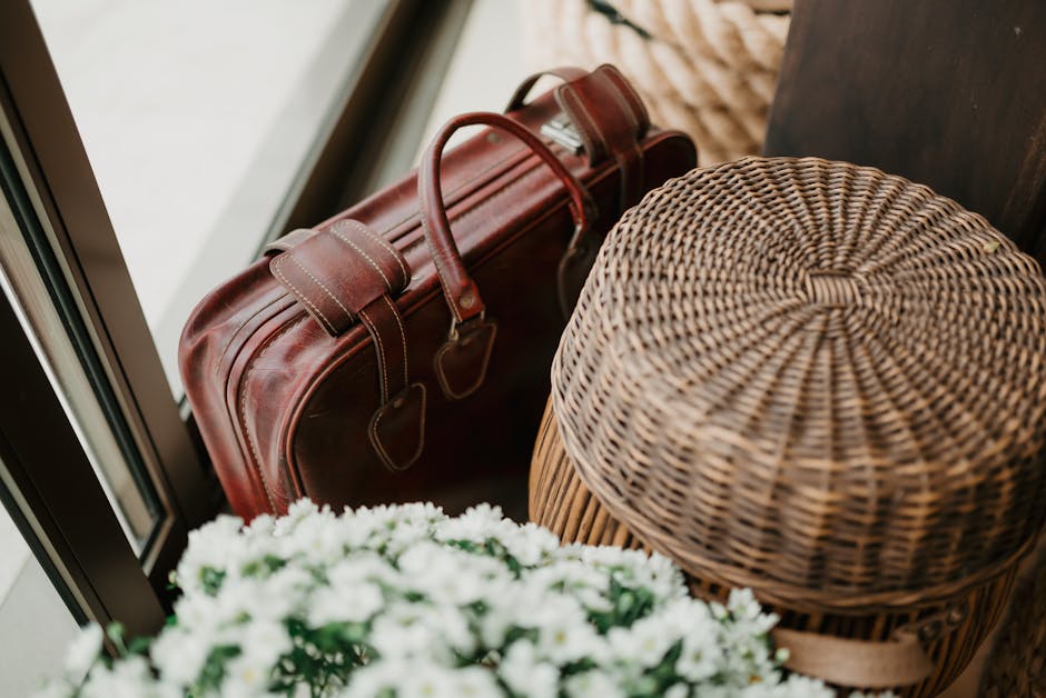 Close-up of a vintage leather bag with wicker basket and flowers, exuding rustic charm.