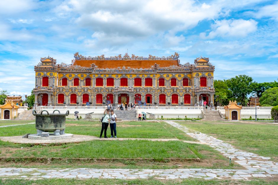 Tourists enjoying the historic Imperial Palace in Hue, Vietnam on a sunny day.