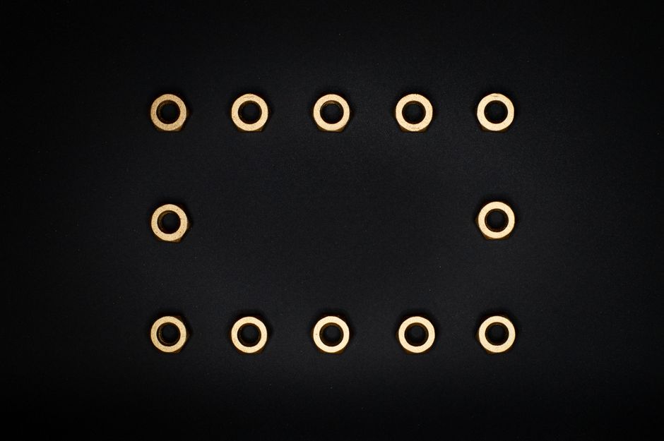 Minimalist composition of golden bolts arranged on a black background.