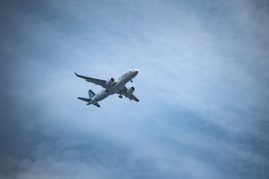 Airplane soaring through a clear blue sky, capturing a dynamic aerial view.